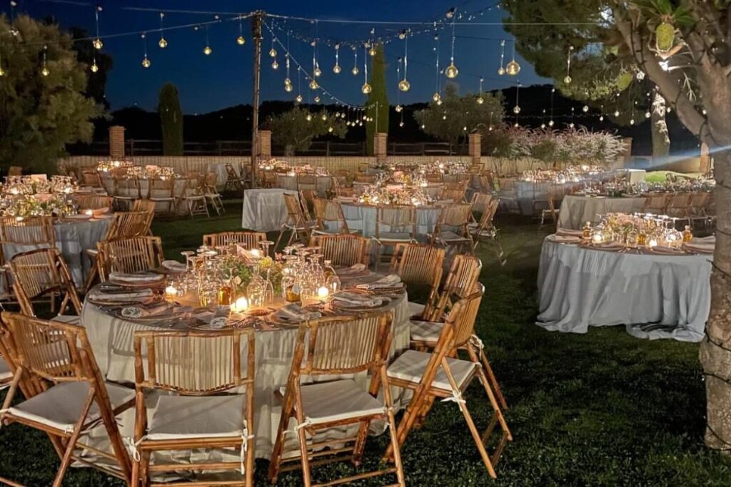 Cena de boda iluminada en el jardín del Complejo Valdepusa